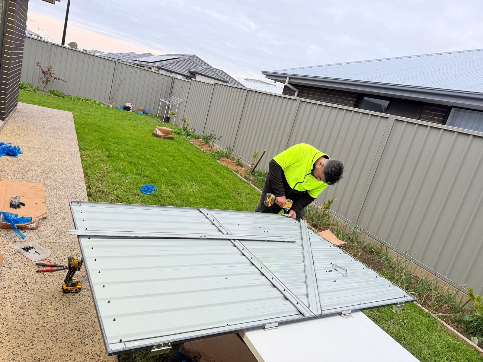 Handyman assembling braced door panel for a metal garden shed