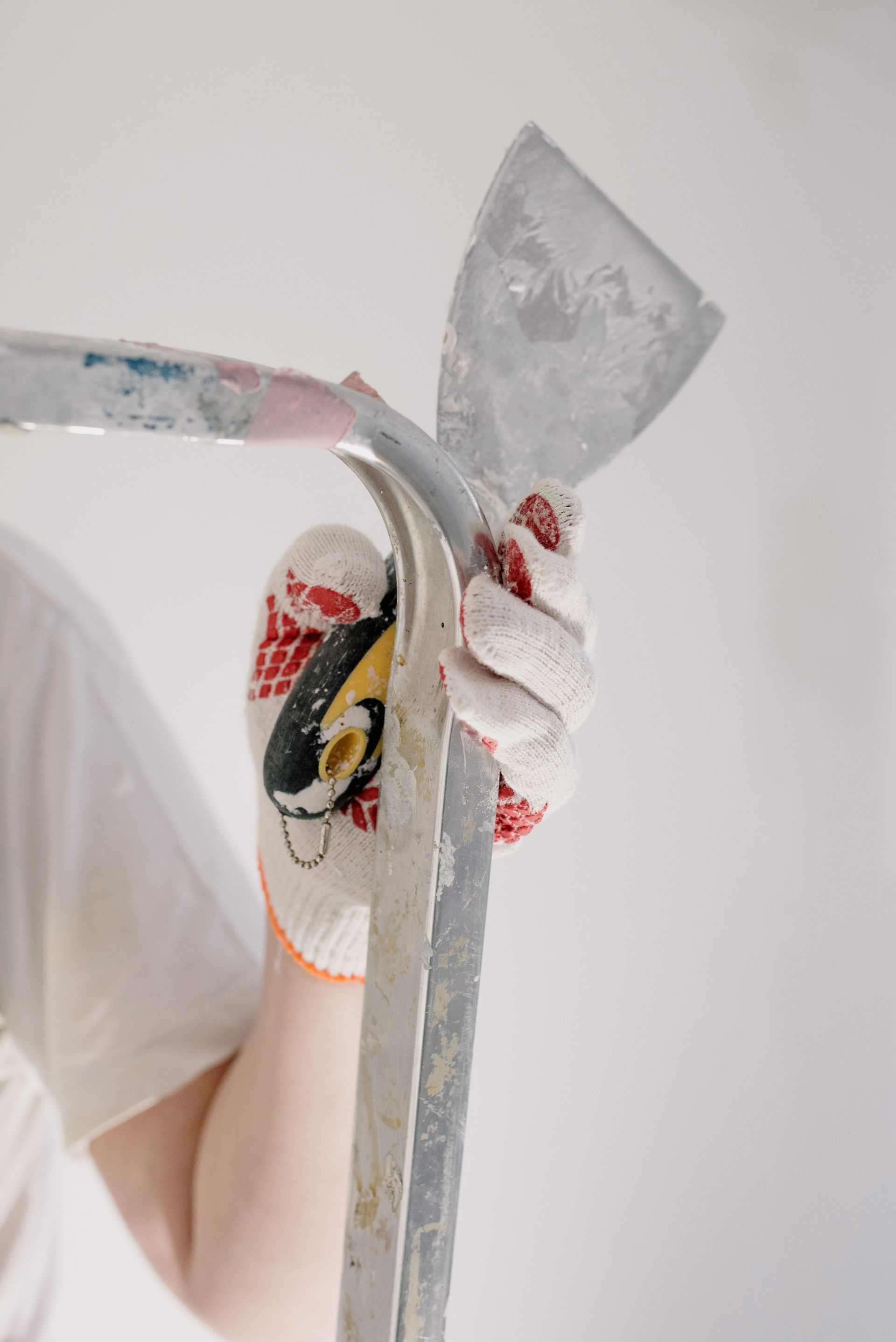 Handyman on a ladder with tools during home repair and plastering work